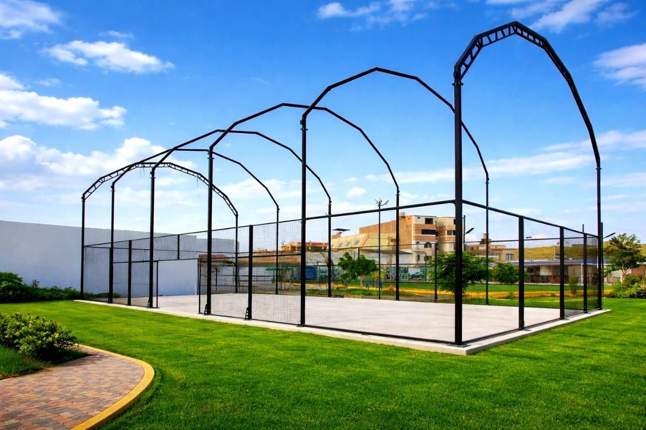 Estructura metálica negra de una cancha techada, con los pórticos en arco montados sobre la losa